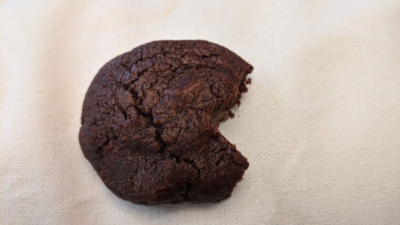 A brown cookie is not quite circular. A piece is missing.