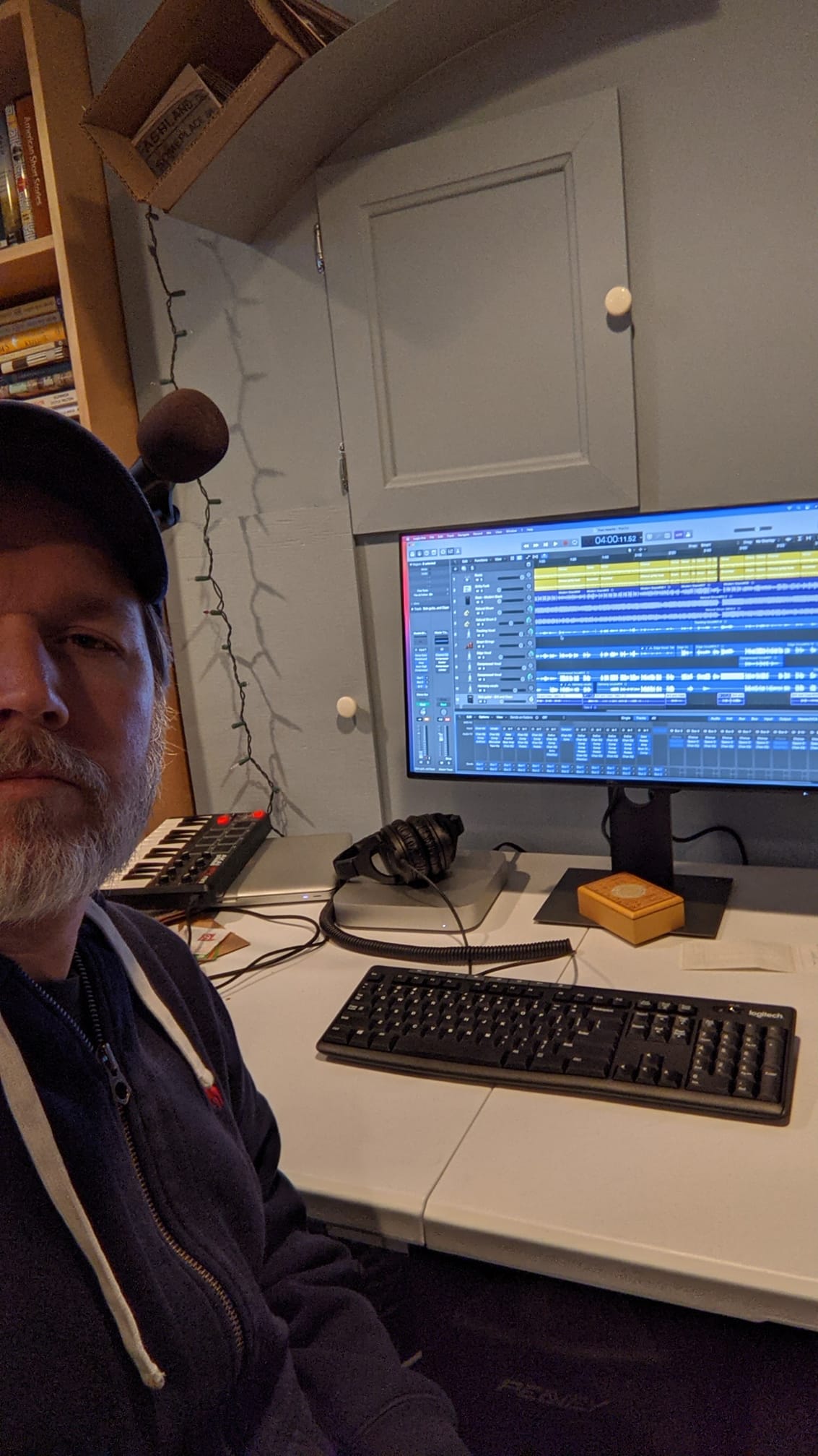 A selfie of the author in front of a computer with music editing software visible on it.